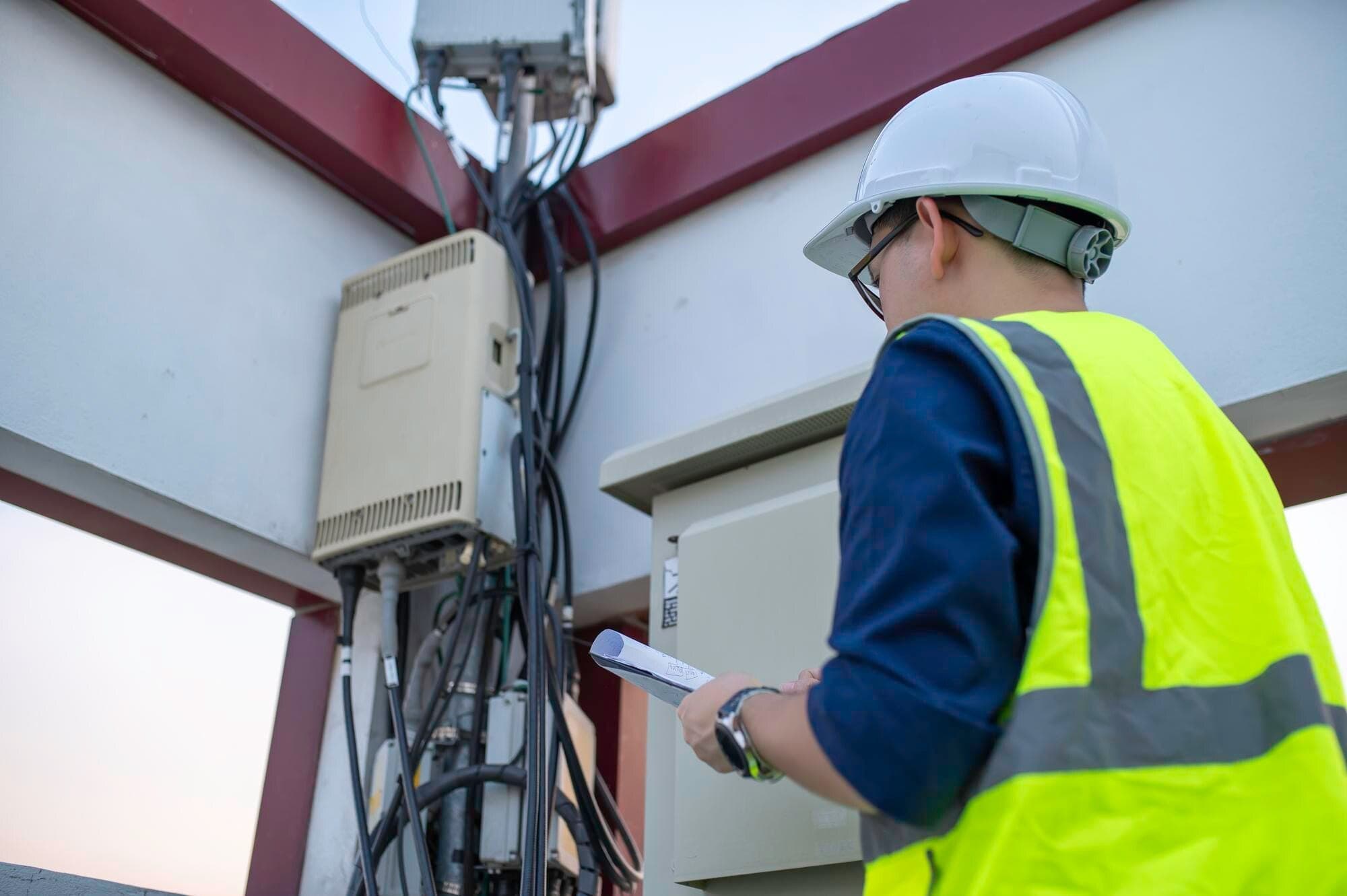 WZC field engineers reviewing plans at the base of a communications tower